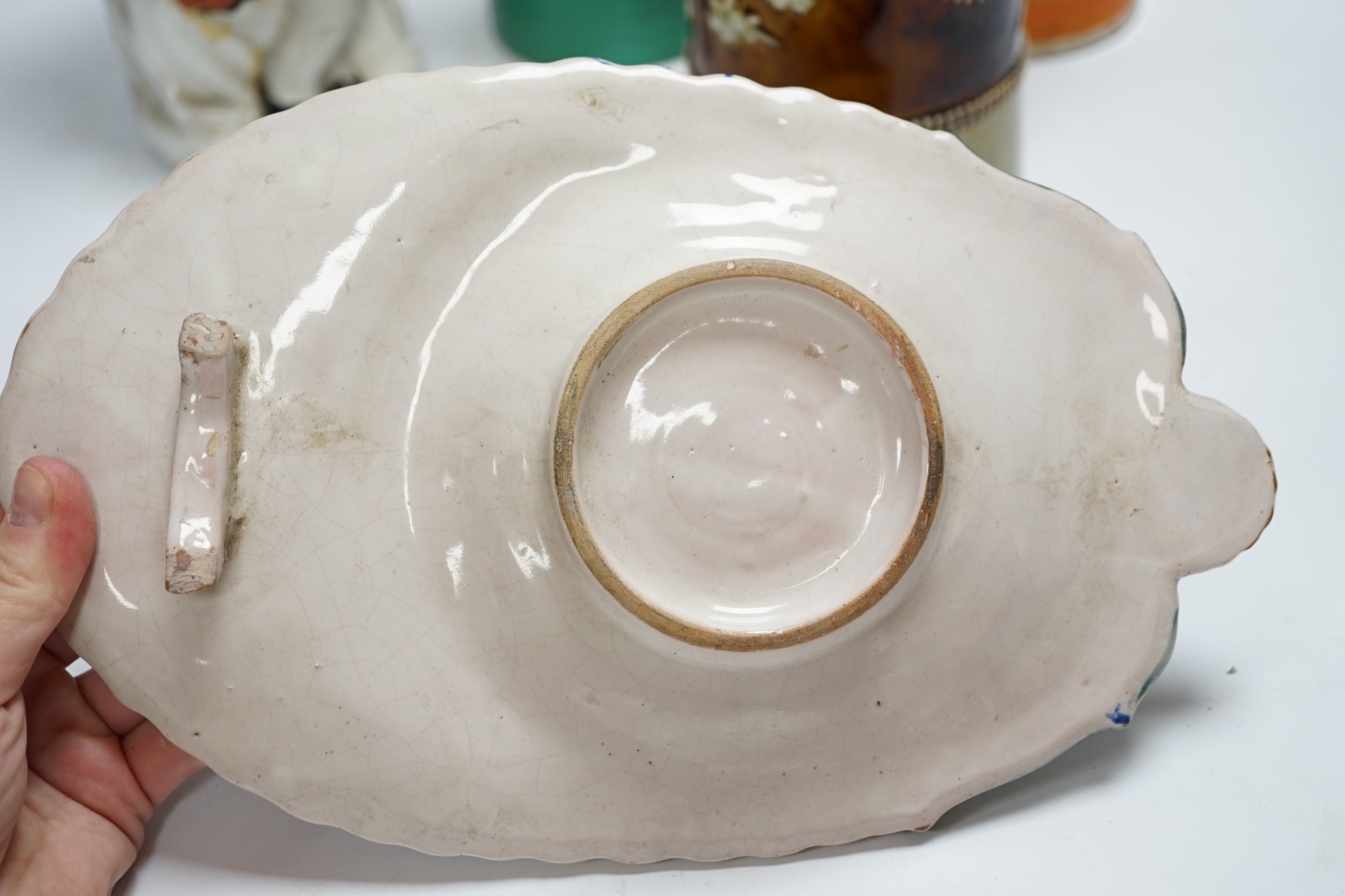 A Bisto jug, two other jugs, a Toby jug and a Quimper saucer, tallest 39cm